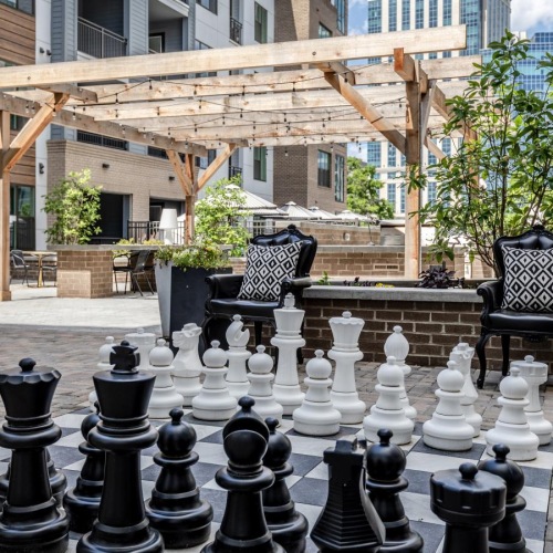 a group of chairs outside in front of a large chess game